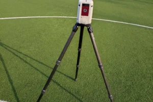 Ekspert budowlany wykonuje skaning laserowy 3D obiektu sportowego przy użyciu skanera RTC 360 firmy Leica, analizując geometrię i stan techniczny konstrukcji.